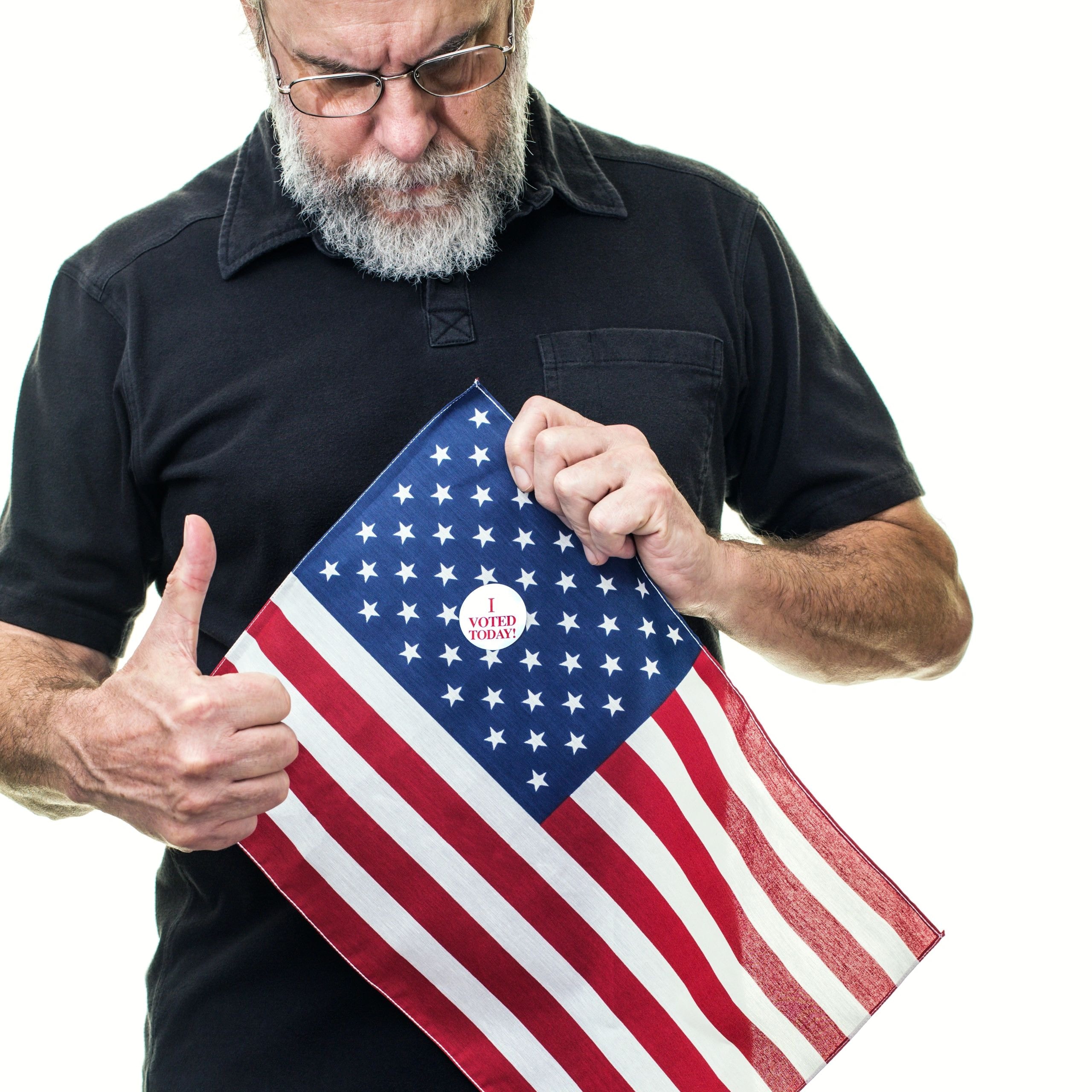 Man holding American flag with I Voted Today sticker